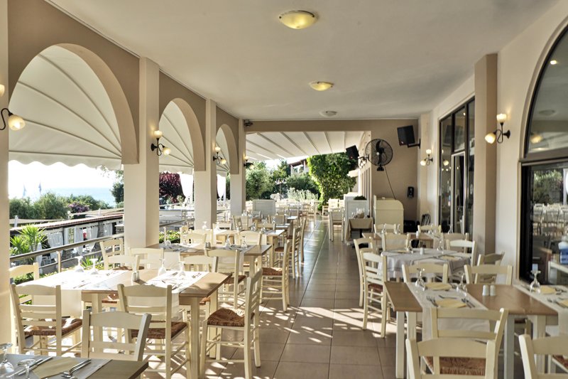Acrotel Elea Beach - stolovi i stolice na terasi restorana.jpg