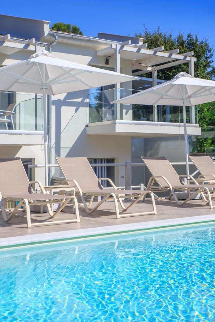 Elegant apartments hotel - ležaljke i suncobrani na strani bazena.jpg